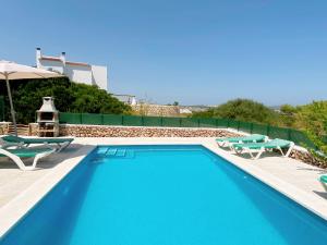 una piscina con tumbonas y una piscina en Villa ELSIE en Arenal d'en Castell