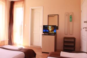 a room with two beds and a flat screen tv at Respekt Guest House in Sunny Beach
