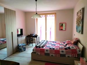 a bedroom with a bed and a table and a window at Appartamento Corte dei Landi in Cavriago