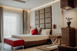 una camera con un grande letto e una sedia rossa di Hotel Niagara a Catanzaro Lido