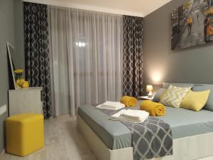 a bedroom with a bed and a yellow stool at Bayview apartments Todorov in Burgas City