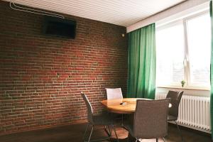ein Esszimmer mit einer Ziegelwand, einem Tisch und Stühlen in der Unterkunft Pension Burglesum Bremen in Bremen