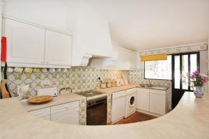 a kitchen with white cabinets and a sink at Casa dos Gemeos in Luz