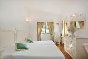 a bedroom with two beds and a dresser and a mirror at Casa dos Gemeos in Luz