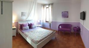 1 dormitorio con cama y silla morada en B&B Dimora Paolina, en Baschi 268 fotos más