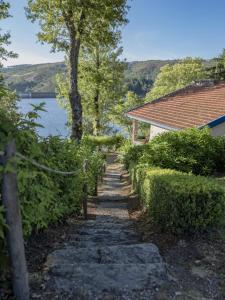 a stone path next to a house and a lake at Morgado - River Suites and Houses by PCH in Padrões