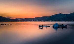 a couple of boats sitting on the water at sunset at Notia Luxury Living in Porto Koufo