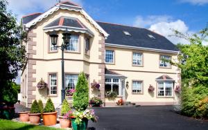 a house with potted plants in front of it at Ballyraine Guesthouse in Letterkenny