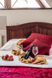 a table with two glasses of wine and strawberries on a bed at Willa Azja SPA & Wellness in Zakopane