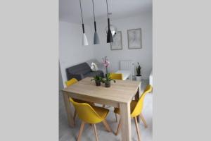 a dining room with a wooden table and yellow chairs at Apartamentos La Herradura Balcón in Haro