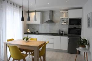 a kitchen with a wooden table and yellow chairs at Apartamentos La Herradura Balcón in Haro