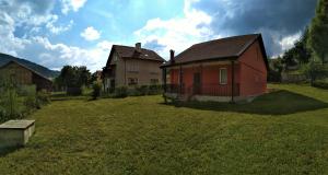 une petite maison rouge dans un champ d'herbe dans l'établissement VILLA IRINA - Govedartsi, à Govedartsi