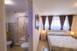 um quarto com uma cama, um chuveiro e um WC em La casa di Lally em Fiano Romano