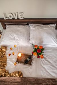 a bed with flowers and a book and a bottle oflove at Willa Azja SPA & Wellness in Zakopane