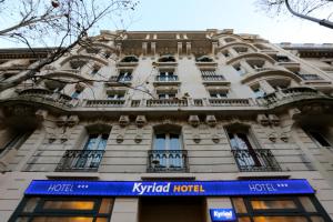 a building with a blue sign in front of it at Kyriad Paris 18 - Porte de Clignancourt - Montmartre in Paris