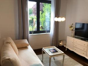 sala de estar con sofá, TV y mesa en Seeblick en Fockbek