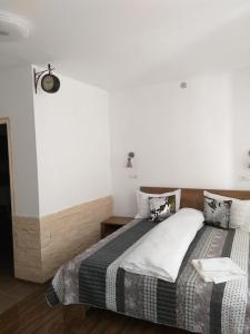 a bedroom with a bed and a white wall at Sara House in Bistriţa