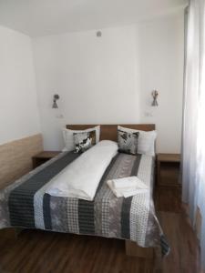 a bedroom with a bed with a black and white comforter at Sara House in Bistriţa