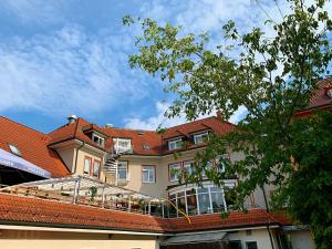 ein großes Gebäude mit rotem Dach in der Unterkunft Hotel Birkenwerder in Birkenwerder