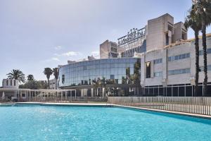 una grande piscina di fronte a un edificio di Silken Al-Andalus Palace a Siviglia