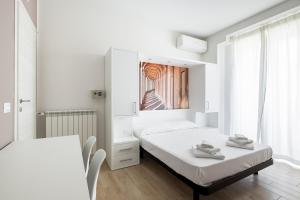 een witte kamer met 2 bedden en een tafel bij Studio II a pochi passi dalla cineteca by Wonderful Italy in Bologna