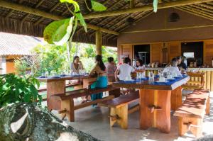 um grupo de pessoas sentadas em mesas em um restaurante em Pousada Estrela do Mar em Caraíva