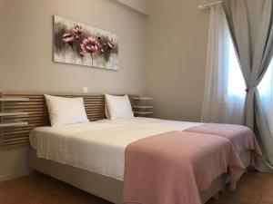 a bedroom with a large white bed and a window at BALATSOURAS APARTMENT in Paleros
