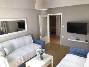 a living room with a couch and a tv at BALATSOURAS APARTMENT in Paleros
