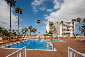 einen Pool mit Palmen und Gebäuden in der Unterkunft Apartment Acapulco Sunset View in Playa Fañabe