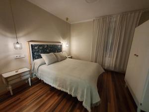 Un dormitorio con una gran cama blanca y una ventana en A Maquia Do Pousavedra, en Sober