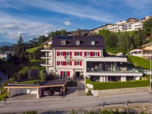 a large white house with red windows at Freiraum 9 Living Apartment in Sankt Johann im Pongau