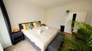 een slaapkamer met een groot bed met oranje kussens bij Luxury 60m2 Apartment with 20m2 Private Terrace in Eindhoven