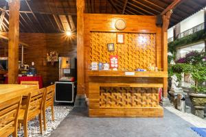 ein Restaurant mit einer Holzwand mit einer Uhr darauf in der Unterkunft OYO 3779 North Wing Canggu Resort in Canggu