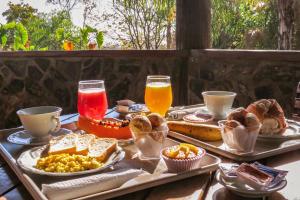 uma bandeja de alimentos e bebidas para o pequeno-almoço numa mesa em Chalé do Bosque em Bonito