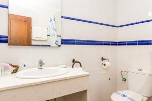 a bathroom with a sink and a toilet and a mirror at Hostal Alhambra in Zahora