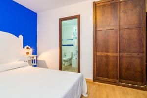a bedroom with a bed and a large wooden closet at Hostal Alhambra in Zahora