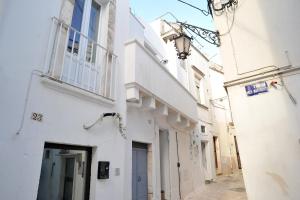 an alley with white buildings and a street light at da Nonna Lata in Martina Franca +7 photos
