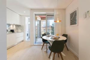a kitchen and dining room with a table and chairs at Heart of D. Pedro Apartments III in Porto