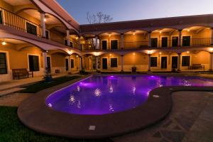 a swimming pool with purple lights in a building at Hotel Los Frailes, Valladolid, Yucatán in Valladolid
