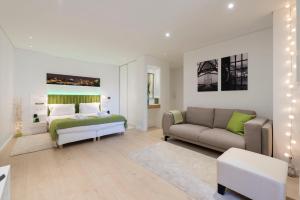 een woonkamer met een bed en een bank bij Heart of D. Pedro Apartments III in Porto