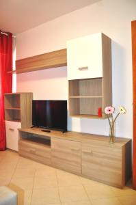 a living room with a tv and a vase with flowers at Via Battisti 231 1 in Pietra Ligure