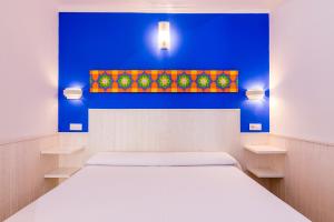 a bedroom with a large bed and a blue wall at Hostal Alhambra in Zahora