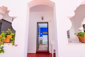 a hallway of a restaurant with white walls and a doorway at Hostal Alhambra in Zahora