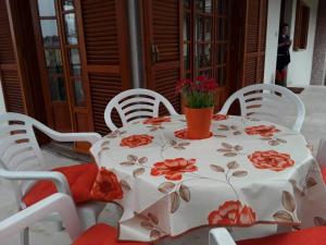 a table with a white table cloth with red flowers on it at Villa Cavaliere in Altino