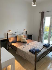 a large bed in a bedroom with a large window at Jalna Apartments - Stunning Sea & Mountain Views with pool - Kassiopi in Kassiopi