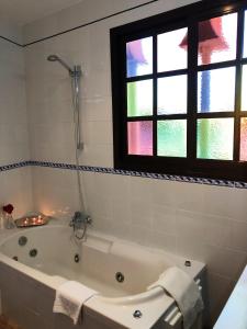 a bath tub in a bathroom with a window at Hostal Alhambra in Zahora