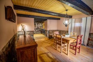 a dining room with a wooden table and chairs at Casa Paulini in Cisnădioara