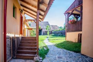 an entrance to a house with a wooden stairway at Casa Paulini in Cisnadioara