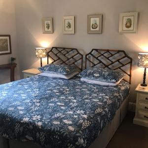 a bed in a bedroom with two lamps on tables at Netherdene Country House Bed & Breakfast in Troutbeck