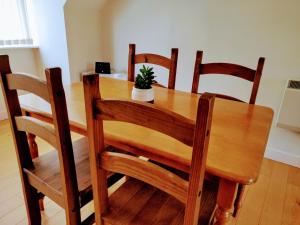 una mesa de madera con 4 sillas y una maceta en ella en 17 Crusader House en Bristol
